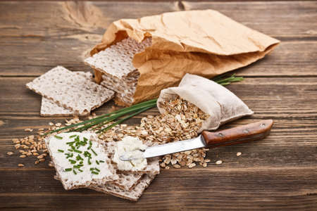 Crispbread with fresh cream cheese on wooden background の写真素材