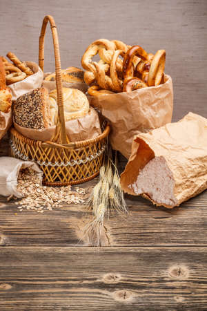 Composition with bread and rolls in wicker basket and paper bag の写真素材