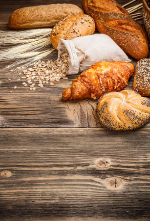 Group of different types of bread  on old wooden tableの写真素材