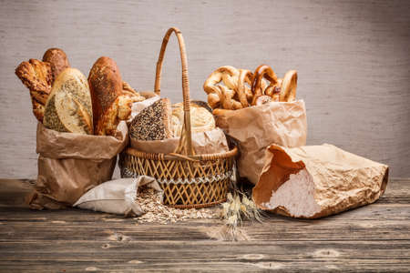 Composition with bread and rolls in wicker basket and paper bag の写真素材