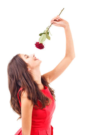 Portrait of happy woman smelling red rose の写真素材