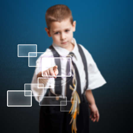 Little boy pressing high tech type of modern buttonsの写真素材