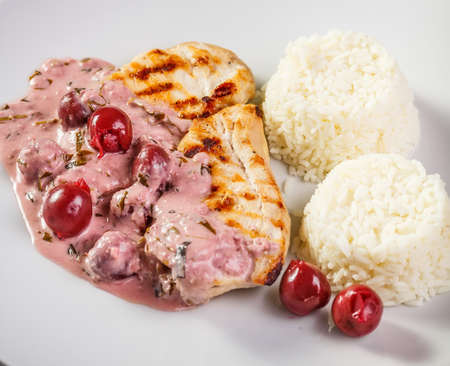 Grilled chicken breast with rice and sour cherry sauceの写真素材