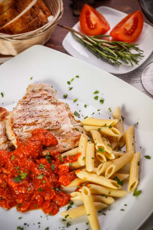 Grilled pork steak meat with tomato sauce and pastaの写真素材