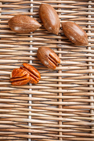 Pecan nuts on wicker board background