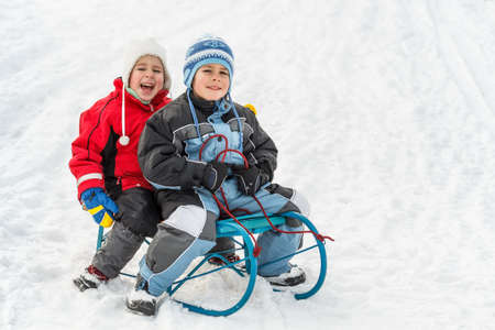 Kids sliding in the snowの写真素材