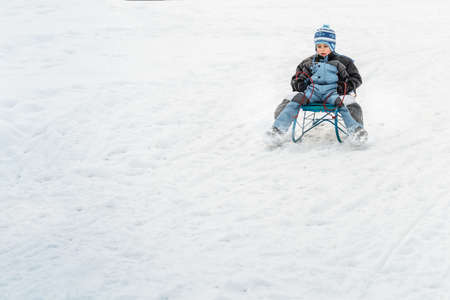 Little boy on sleigh, winter timeの写真素材