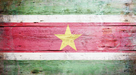 Flag of Suriname painted on grungy wood plank backgroundの写真素材