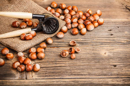 Whole and chopped hazelnuts on vintage wooden backgroundの写真素材