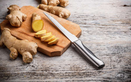 Fresh ginger root on a cutting board の写真素材