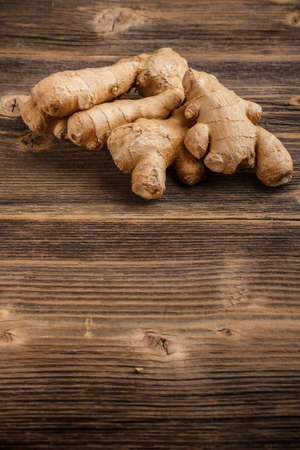Fresh ginger root on wooden background