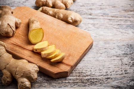 Cutting board with ginger root slicedの写真素材