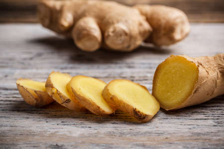 Close up of ginger root sliced on wooden tableの写真素材