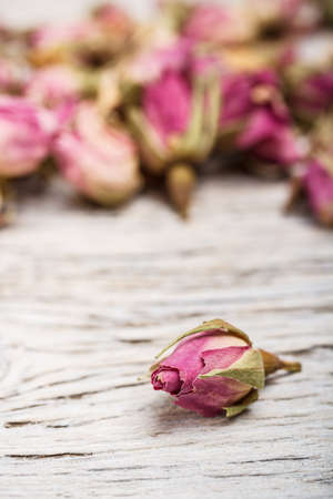 Dried rose buds on wooden tableの写真素材