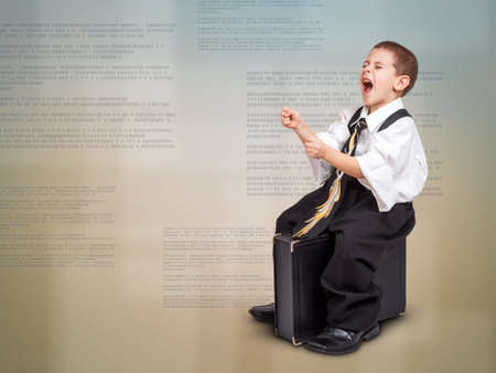 Business concept with boy sitting on a briefcase, leads to success の写真素材