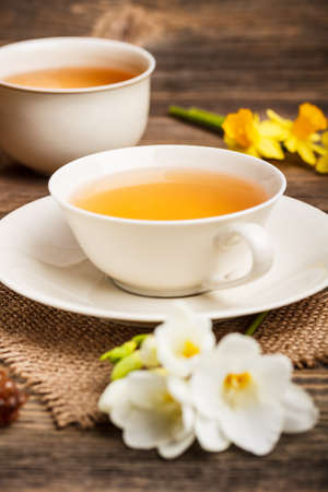 Cup of black tea with freesia flowersの写真素材
