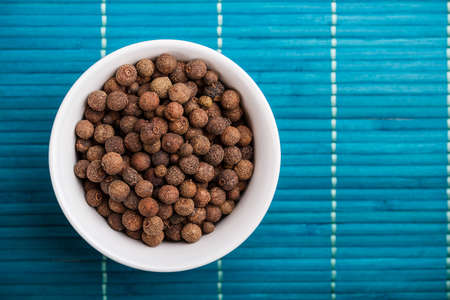 Dried allspice in ceramic bowl の写真素材