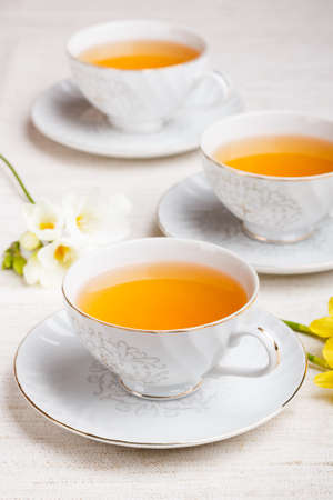 Cup of black tea with daffodilの写真素材