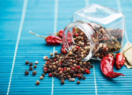 Mixture of different peppers sprinkled from a glass jarの写真素材