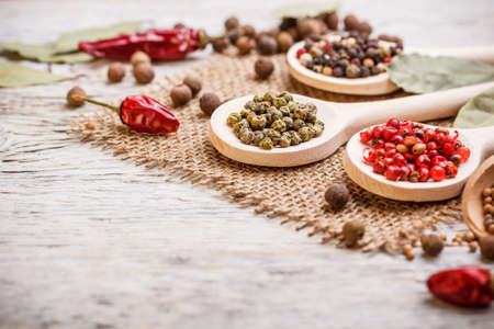 Spices assortment in wooden spoons on a burlapの写真素材