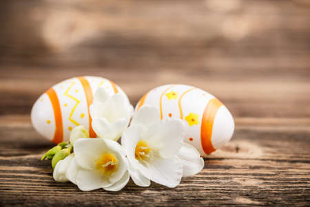 Easter composition with eggs and freesia flowers on wooden の写真素材