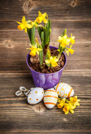 Spring flowers and easter eggs on rustic wooden tableの写真素材