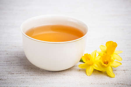 Cup with tea and a flower の写真素材
