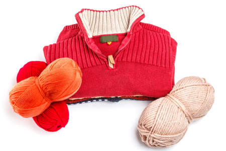 Sweaters and balls of wool isolated on white 
