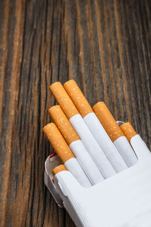 Pile of cigarettes on rustic wooden backgroundの写真素材