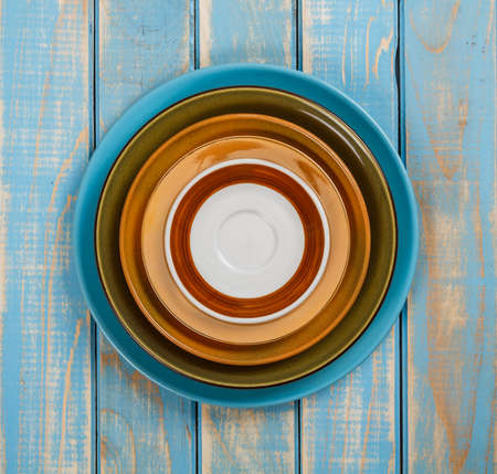 Colorful plates on painted blue wooden tableの写真素材