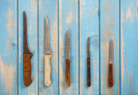 Set of knifes on painted blue wooden boardの写真素材