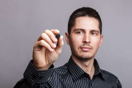 Business man writing something on glass board with marker の写真素材