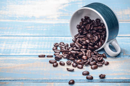 Coffee cup and spilled coffee beansの写真素材