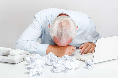 Tired and exhousted businessman with laptop and telephone