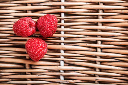 Three raspberry in the wicker trayの写真素材