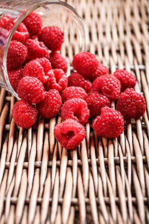 Raspberries scattered on wicker trayの写真素材
