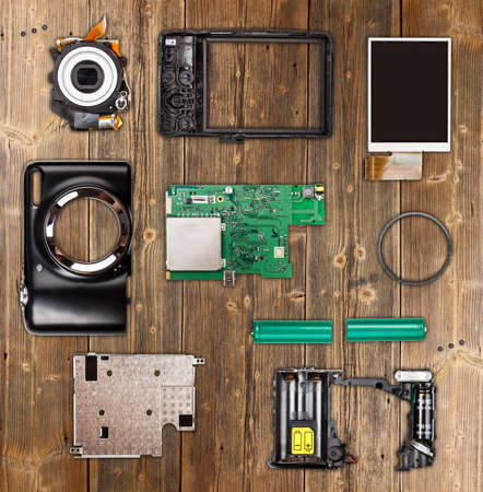 Compact digital photo camera components on wooden backgroundの写真素材