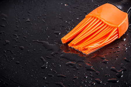 Oiling the frying pan using the silicone brush の写真素材