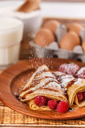 Pancakes with fresh raspberries and powdered sugar