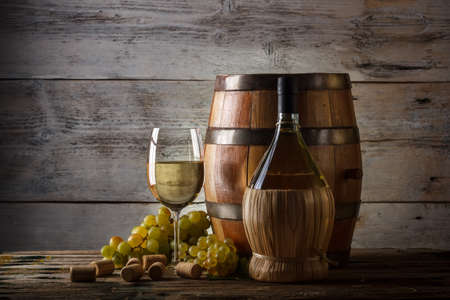 Barrel, bottles and glass of wine and ripe grapesの写真素材