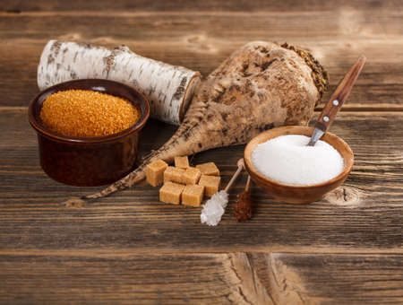 White and brown sugar in bowl on a  wooden surface の写真素材
