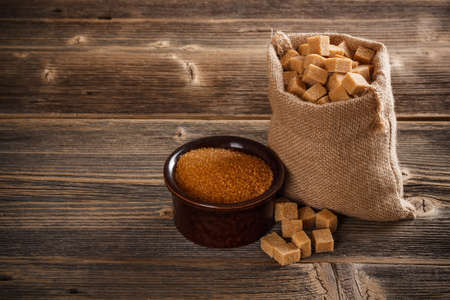 Brown cane sugar cubes in burlap sackの写真素材