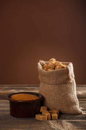 Brown sugar bowl and lump sugar in burlap sackの写真素材