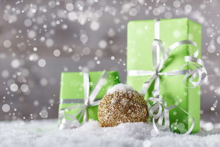 Christmas gift and bauble in snowの写真素材