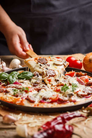 Supreme homemade pizza lifted slice