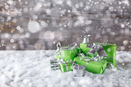 Green Christmas presents in snowの写真素材