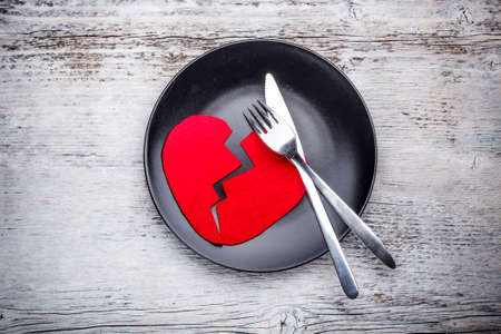 Plate with broken heart on wooden backgroundの写真素材