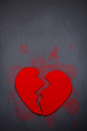 Red broken heart on grey background