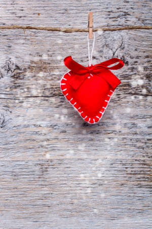 Red heart made of felt on wooden backgroundの写真素材