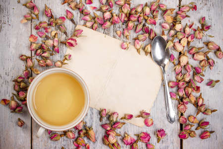 Cup of tea with rose bud and vintage paper, copyspaceの写真素材